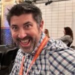 Dustin Howes, Affiliate Guru, smiling at an affiliate marketing summit, expressing satisfaction with event support.